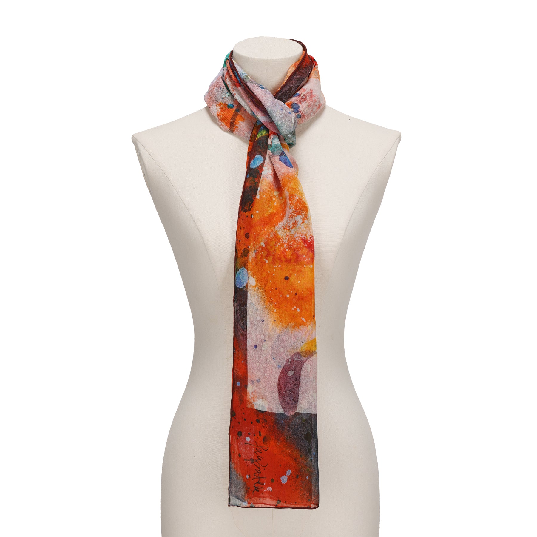 A mannequin showcases the Multicolor Silk Scarf Cangrejos—a long, lightweight silk piece featuring an abstract design in vibrant orange, red, blue, and white—elegantly tied around the neck like a piece of wearable art.