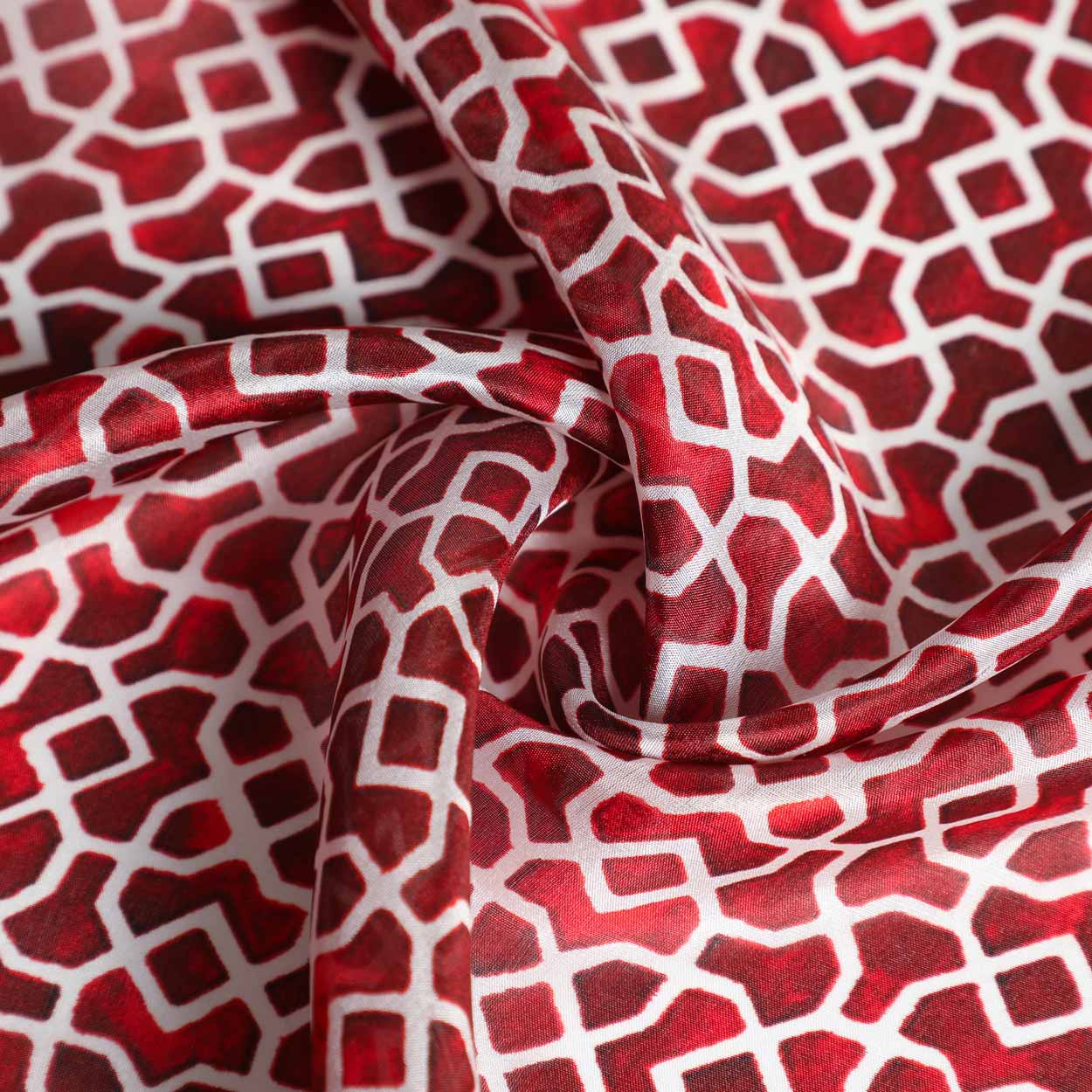 Close-up of Andalusian silk scarf with red and white geometric patterns, showcasing its soft and luxurious texture.