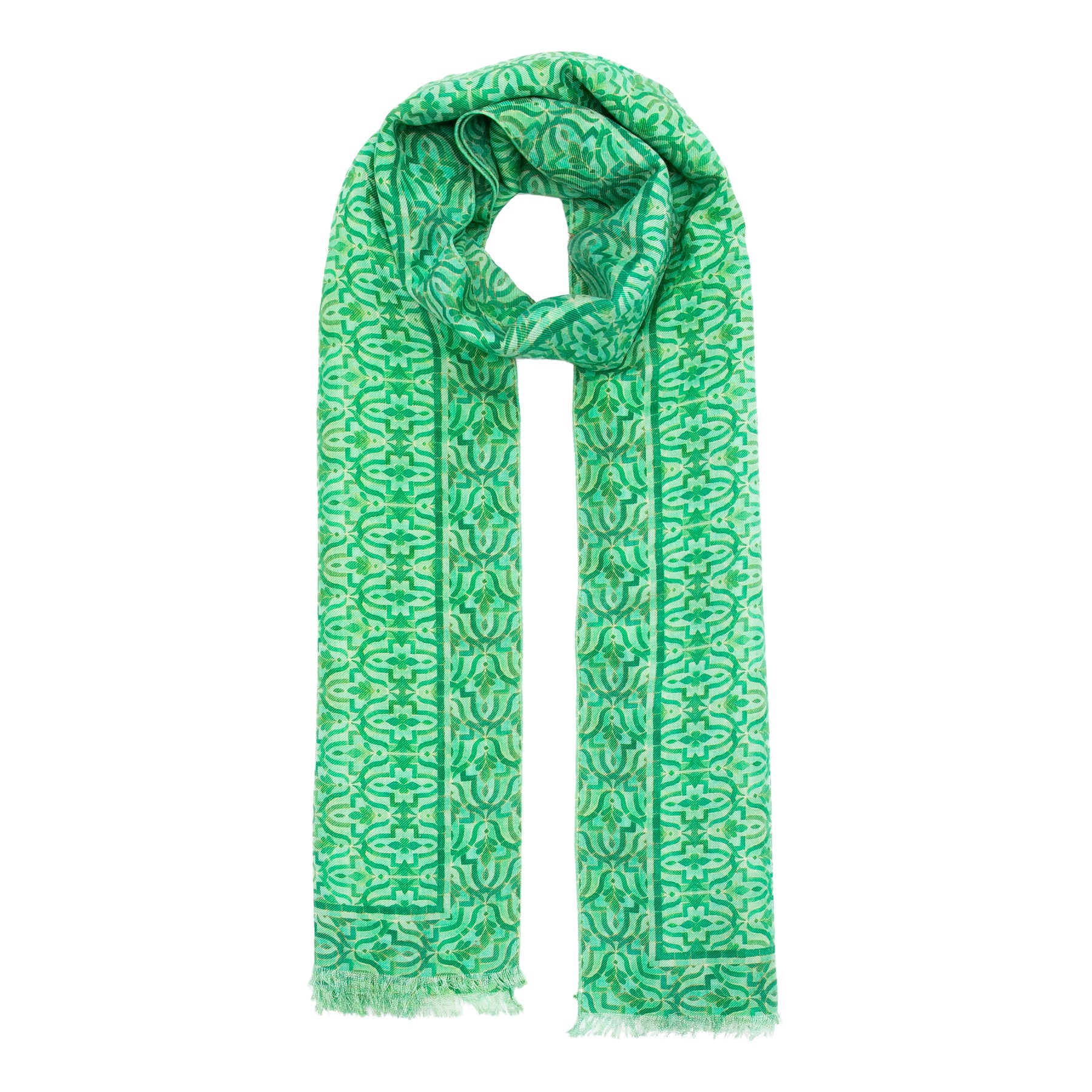 The Green Silk and Wool Scarf Ahdar by Hamzah features vibrant geometric prints and fringed ends, elegantly displayed on a plain white background.