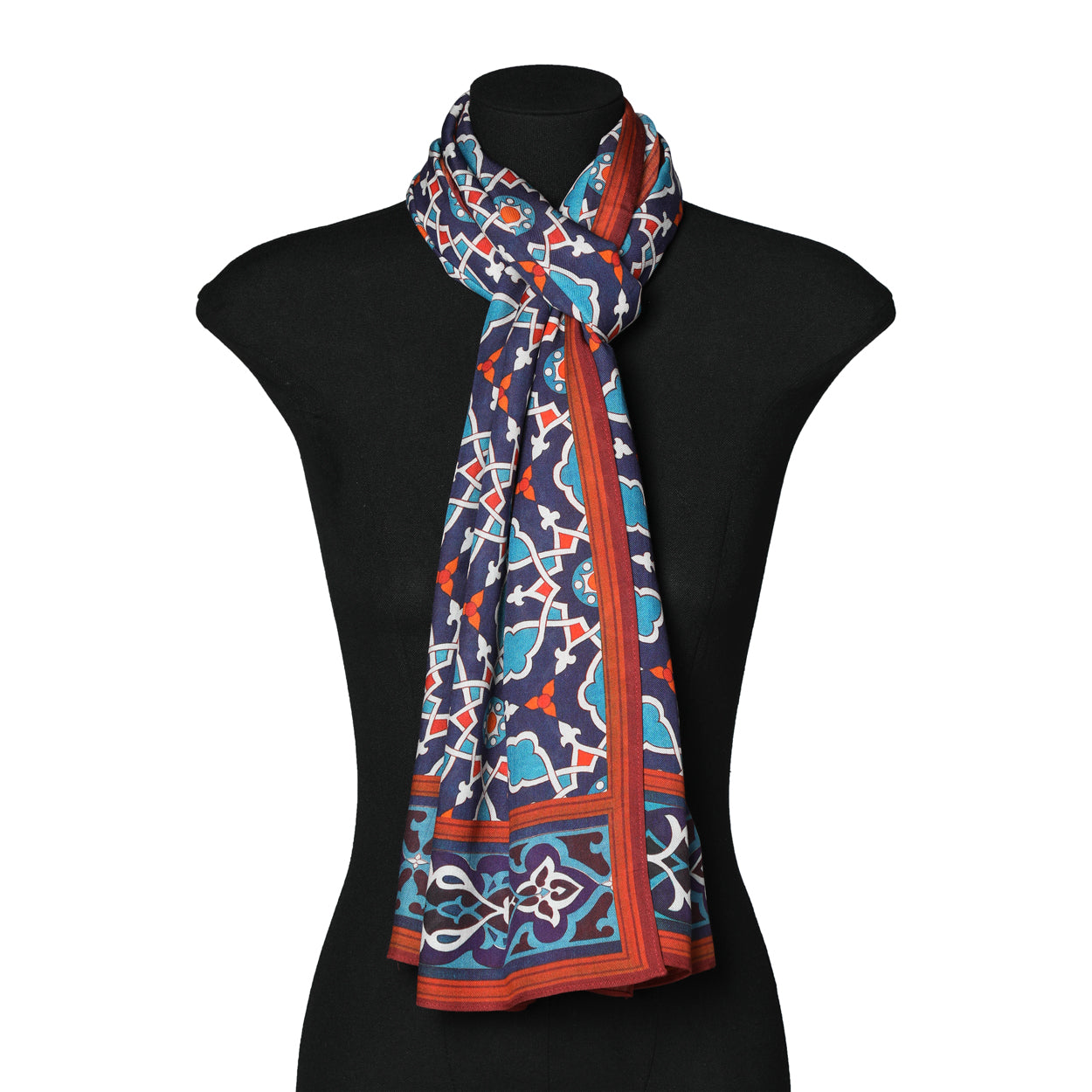 The scarf styled as a neck scarf on a mannequin, showcasing the vibrant geometric design.