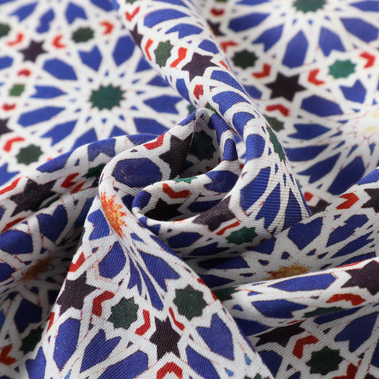 Close-up of the texture of an Islamic art-inspired scarf with geometric details in blue and white