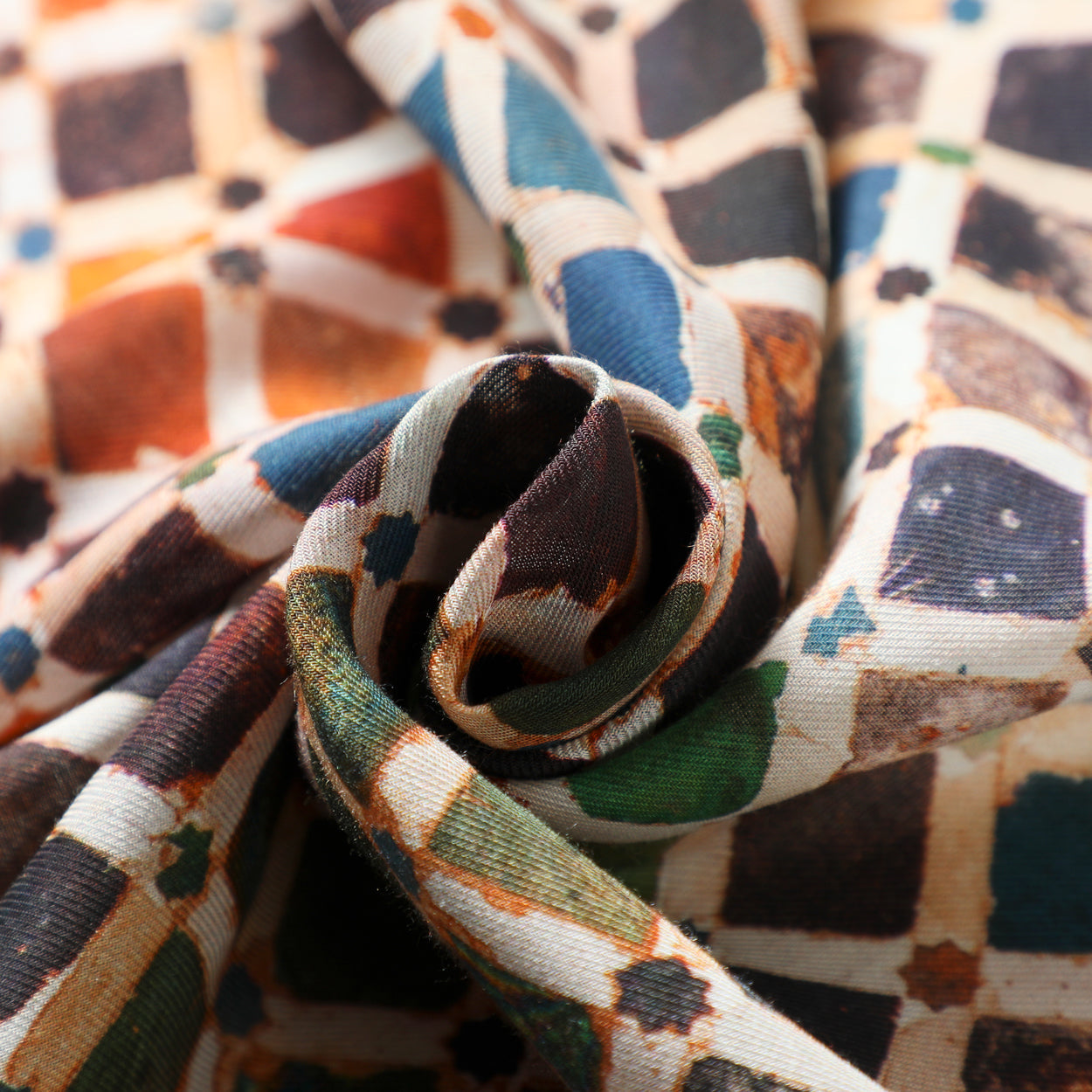 Close-up of scarf fabric showcasing intricate tile-inspired patterns.