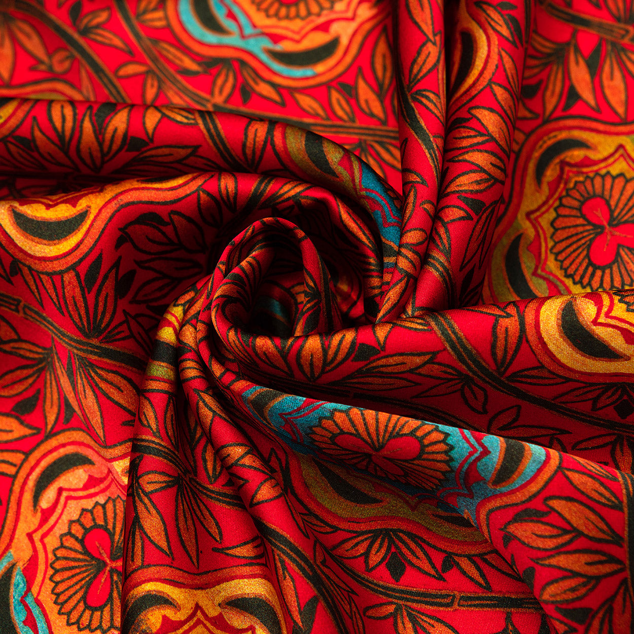 Closer view of the red scarf’s swirling leaf-and-floral design, showcasing rich orange and teal hues on a crimson base.