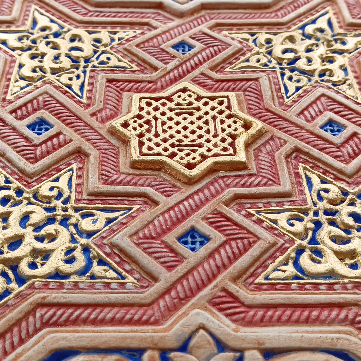 Detail of hand painted plaster art piece inspired by the walls of the Alhambra of Granada for modern islamic home decor