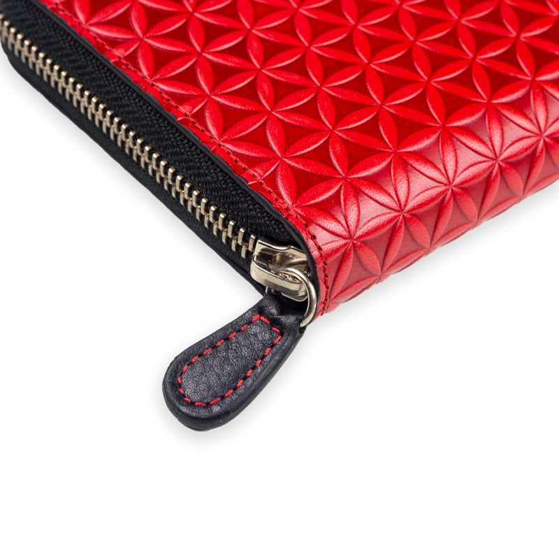 Detail of red leather wallet with flower of life embossed pattern and zipper