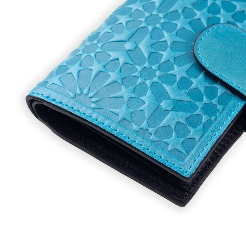 Close up of blue leather wallet for women with geometric pattern inspired by islamic art